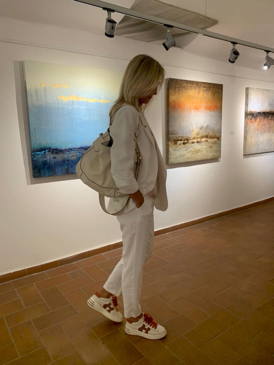 Gabriela Aleksandra Szuba in una galleria osserva le sue opere